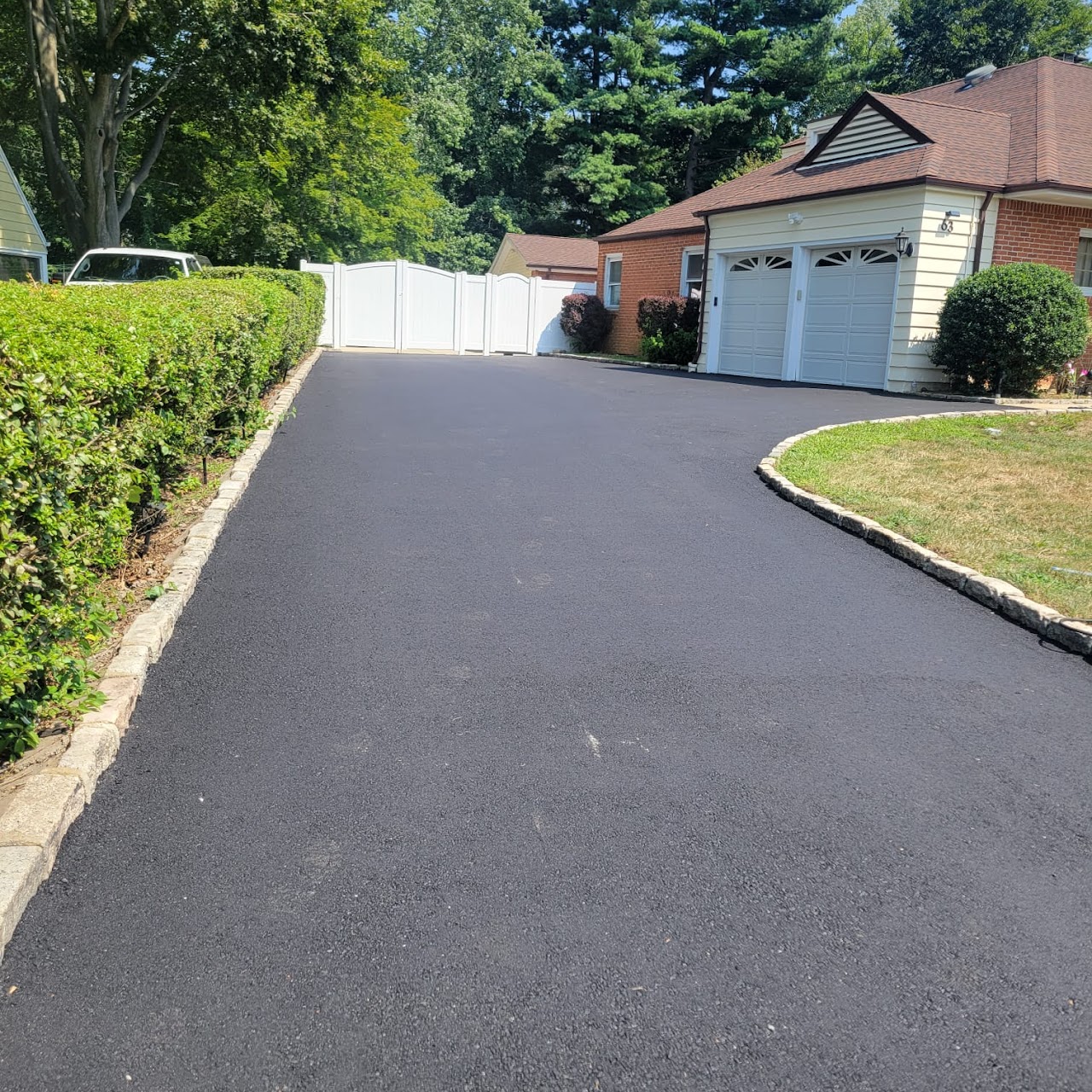 Palm Beach County home featuring a fresh asphalt driveway installation by A-Top Paving (DBA Florida Paving Pros), with precise edging and seamless finish.