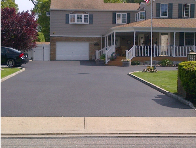 Professional asphalt driveway installation by A-Top Paving (DBA Florida Paving Pros) in Palm Beach County, showcasing a pristine black surface with clean edges and stone borders.